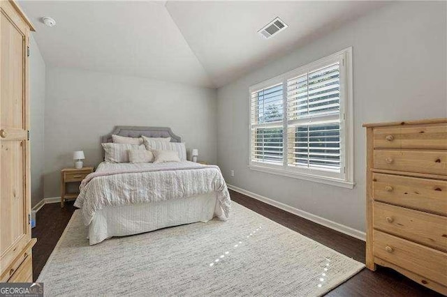 bedroom with baseboards, dark wood-style flooring, and vaulted ceiling