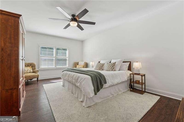 bedroom featuring baseboards, dark wood finished floors, a ceiling fan, and lofted ceiling