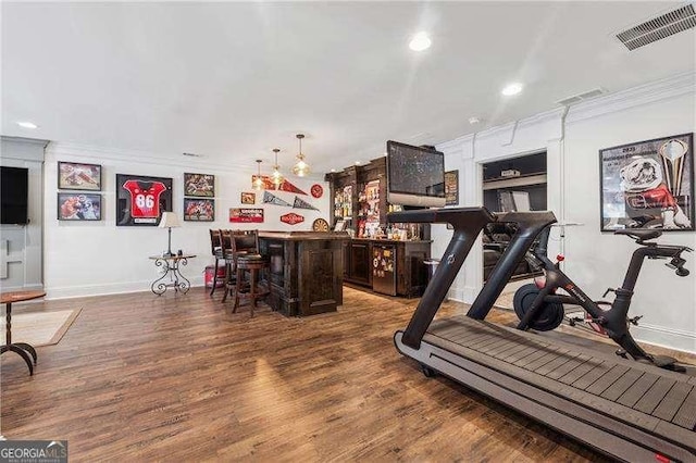 exercise area with a bar, crown molding, baseboards, wood finished floors, and recessed lighting