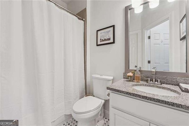 bathroom with toilet, vanity, and curtained shower