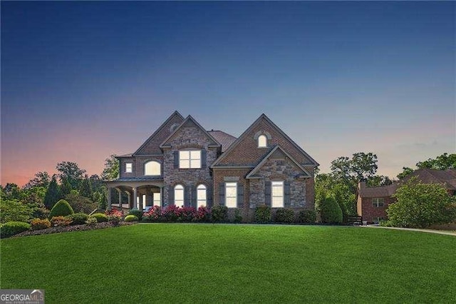 view of front of house with a front lawn and stone siding