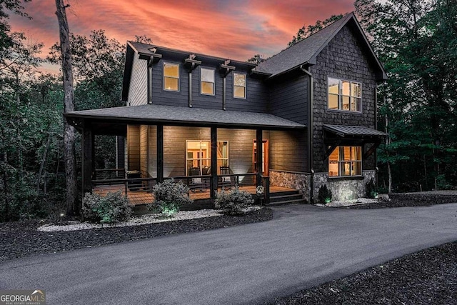view of front of house with covered porch and stone siding