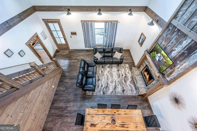 living area featuring plenty of natural light, wood finished floors, and beam ceiling