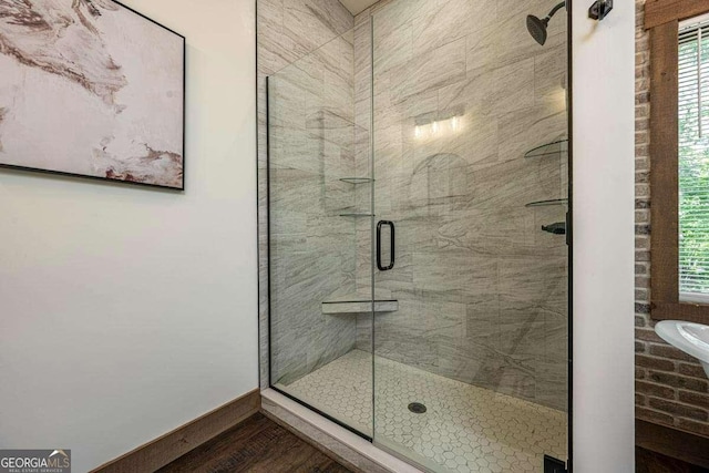 full bathroom with a shower stall, wood finished floors, baseboards, and plenty of natural light