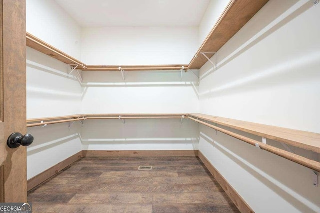 spacious closet with dark wood-type flooring