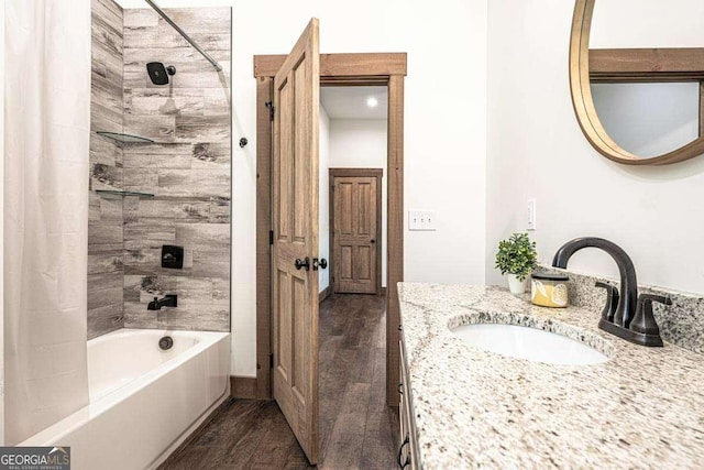 full bathroom with wood finished floors, shower / bathtub combination with curtain, and vanity