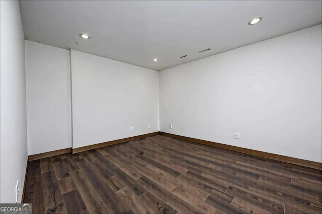 unfurnished room featuring dark wood-type flooring, recessed lighting, and baseboards