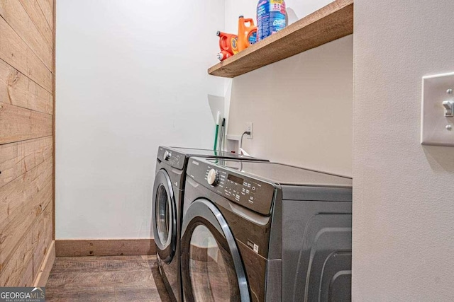 washroom featuring washer and clothes dryer, wood finished floors, and baseboards