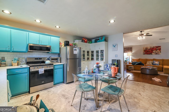 kitchen with appliances with stainless steel finishes, blue cabinetry, recessed lighting, a ceiling fan, and light countertops