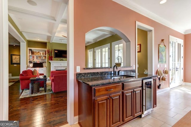 18 Enclave Cir, Savannah, GA 31419 - kitchen with beverage cooler, a sink, arched walkways, dark stone counters, and ornamental molding