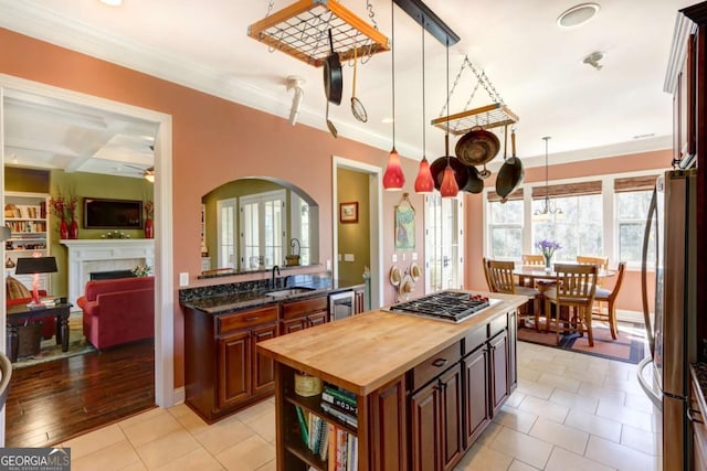 18 Enclave Cir, Savannah, GA 31419 - kitchen with butcher block counters, stainless steel appliances, a tile fireplace, a sink, and arched walkways