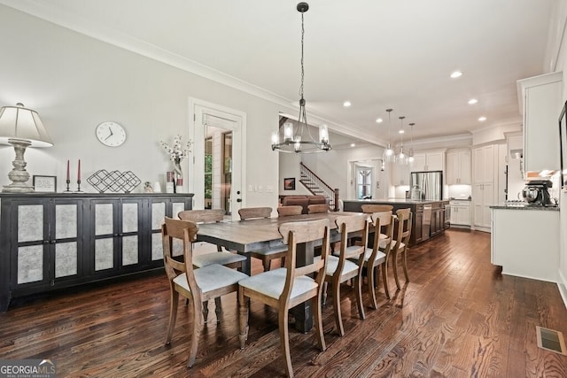 2861 Digna Ct, Acworth, GA 30101 - dining space featuring a chandelier, crown molding, dark wood-type flooring, recessed lighting, and stairs