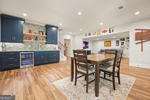 2861 Digna Ct, Acworth, GA 30101 - dining room with wine cooler, wet bar, crown molding, light wood-style flooring, and recessed lighting