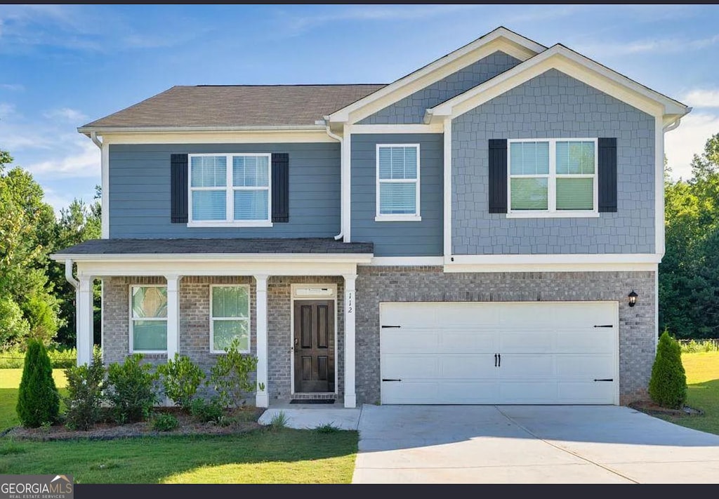 112 Russell Rd, Pendergrass, GA 30567 - craftsman-style house featuring driveway, a garage, brick siding, and a front yard