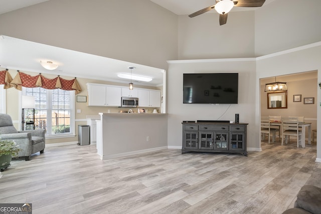 3 Bluegrass Pass, Newnan, GA 30263 - living area featuring a high ceiling, light wood-style flooring, ceiling fan, baseboards, and a chandelier