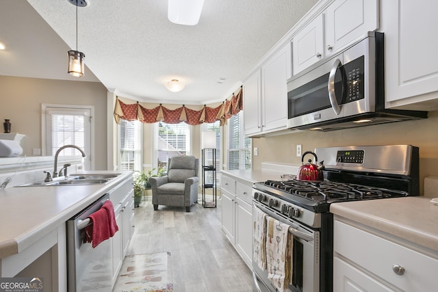 3 Bluegrass Pass, Newnan, GA 30263 - kitchen with appliances with stainless steel finishes, a sink, white cabinets, light countertops, and light wood-type flooring