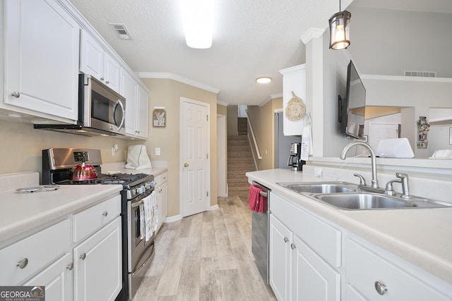3 Bluegrass Pass, Newnan, GA 30263 - kitchen featuring stainless steel appliances, a sink, crown molding, white cabinetry, and light wood-style floors