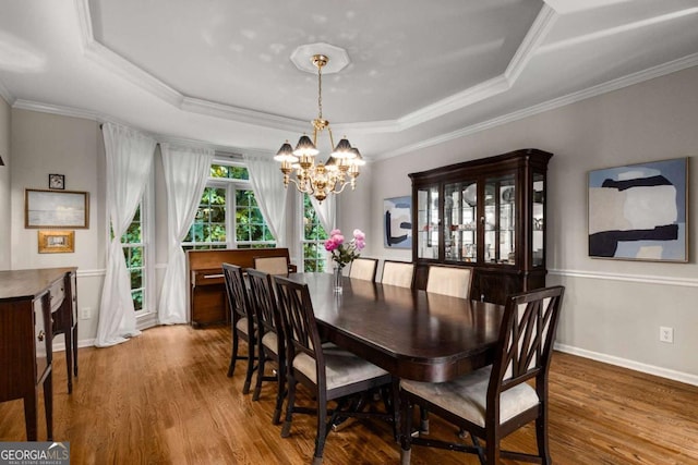 2759 Thomashire Trce, Marietta, GA 30066 - dining area featuring a chandelier, a raised ceiling, wood finished floors, ornamental molding, and baseboards