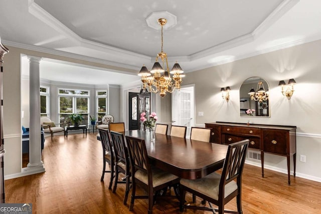 2759 Thomashire Trce, Marietta, GA 30066 - dining space featuring a chandelier, decorative columns, a tray ceiling, wood finished floors, and ornamental molding