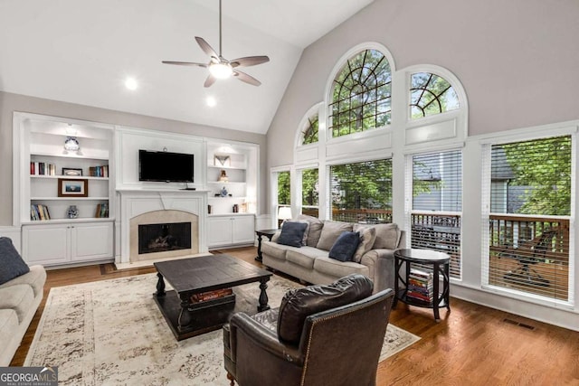 2759 Thomashire Trce, Marietta, GA 30066 - living room featuring high vaulted ceiling, a ceiling fan, wood finished floors, a fireplace with flush hearth, and built in shelves