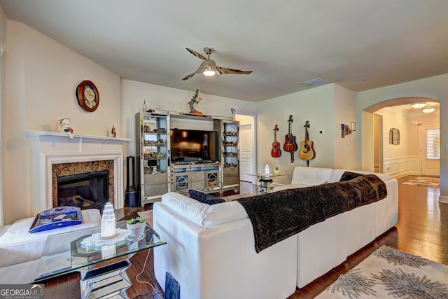 778 Firefly Ct, Griffin, GA 30223 - living room with a ceiling fan, arched walkways, wood finished floors, a high end fireplace, and wainscoting
