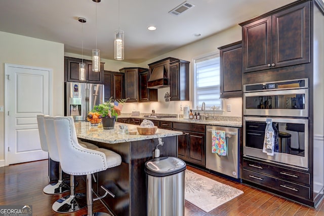 778 Firefly Ct, Griffin, GA 30223 - kitchen featuring appliances with stainless steel finishes, a sink, dark brown cabinetry, custom exhaust hood, and light stone counters