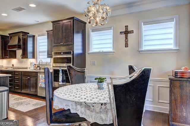 778 Firefly Ct, Griffin, GA 30223 - dining space with a chandelier, wainscoting, dark wood-type flooring, a decorative wall, and recessed lighting