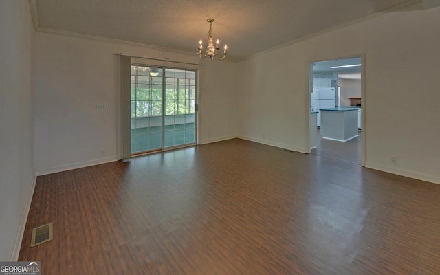 empty room featuring a chandelier, crown molding, dark wood-style floors, and baseboards