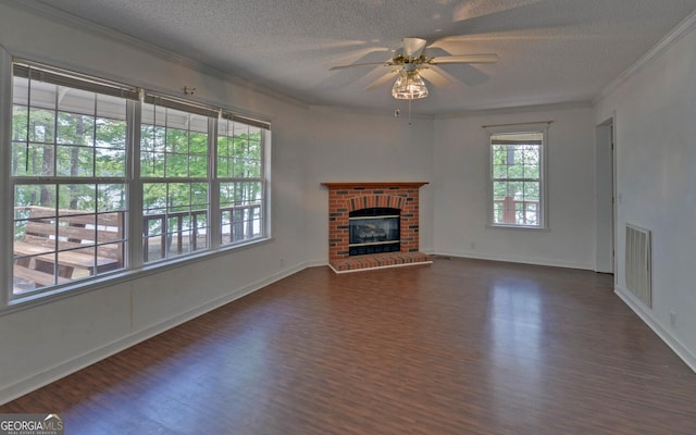 unfurnished living room with dark wood-type flooring, a textured ceiling, ornamental molding, ceiling fan, and baseboards