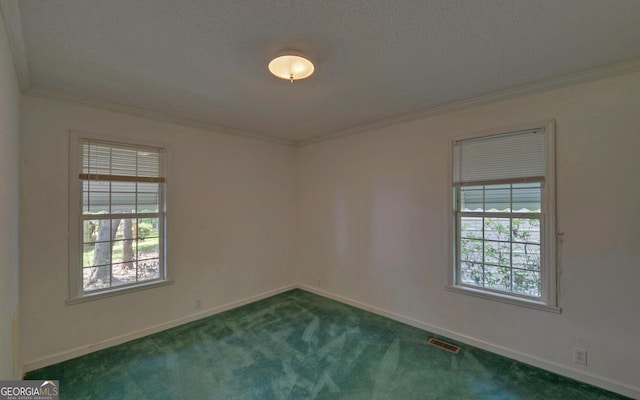 empty room featuring ornamental molding, dark colored carpet, and baseboards