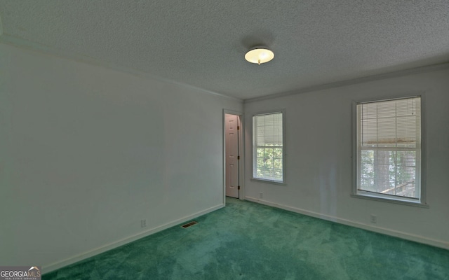 carpeted spare room with a textured ceiling and baseboards