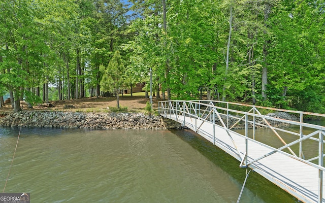 dock featuring a water view and view of wooded area