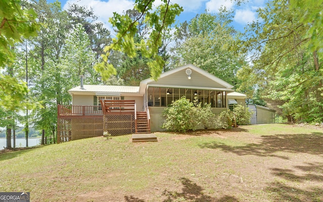 back of house featuring a deck with water view, stairs, a sunroom, and a yard