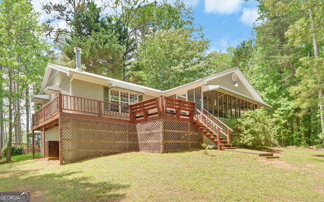 rear view of property featuring stairs, a yard, a wooden deck, and a sunroom
