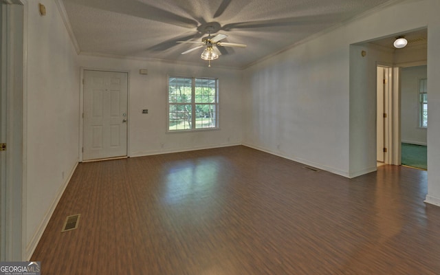spare room featuring ceiling fan, crown molding, dark wood finished floors, baseboards, and a textured ceiling