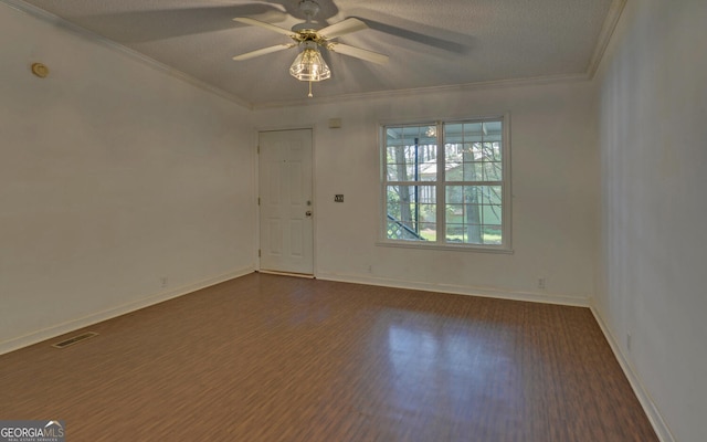 spare room featuring dark wood-type flooring, a ceiling fan, ornamental molding, baseboards, and a textured ceiling