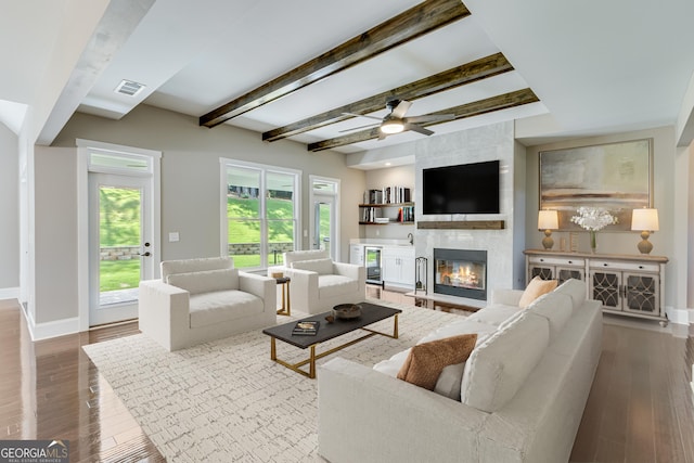 living area with baseboards, a fireplace, dark wood-style flooring, beamed ceiling, and wine cooler