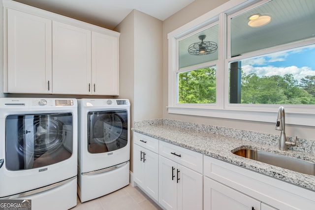 clothes washing area featuring cabinet space, washing machine and clothes dryer, and light tile patterned floors