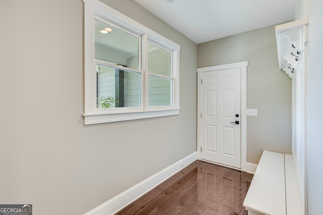 doorway to outside featuring baseboards and dark wood-style flooring