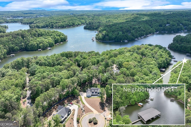 view of property location with a heavily wooded area, property parcel outlined, and a nearby body of water