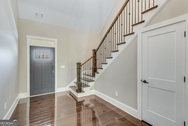 entryway featuring stairs, baseboards, and wood finished floors