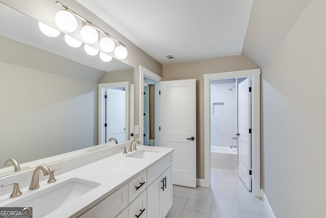 full bath with tile patterned floors, double vanity, vaulted ceiling, and baseboards