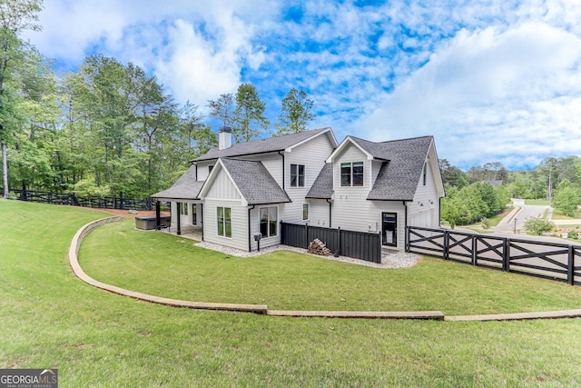 rear view of property with a shingled roof, an attached garage, a chimney, board and batten siding, and a gate