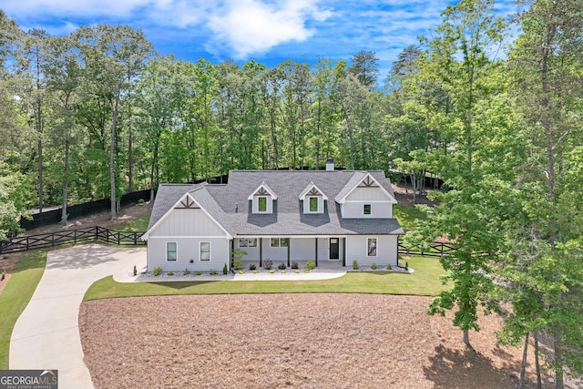 6011 Tradewinds Cv, Gainesville, GA 30506 - view of front of home with board and batten siding, driveway, a chimney, and roof with shingles