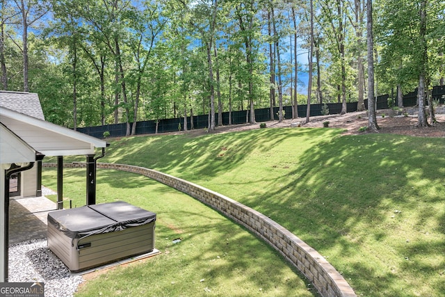 view of yard featuring a hot tub and view of scattered trees