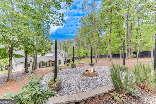 fenced yard featuring an outdoor fire pit