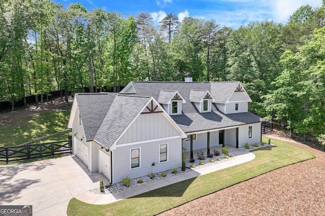modern inspired farmhouse featuring board and batten siding, a shingled roof, concrete driveway, a garage, and a porch
