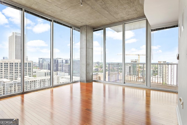 855 Peachtree St NE Unit 2203, Atlanta, GA 30308 - unfurnished sunroom featuring hardwood / wood-style floors, healthy amount of natural light, a wall of windows, and a city view