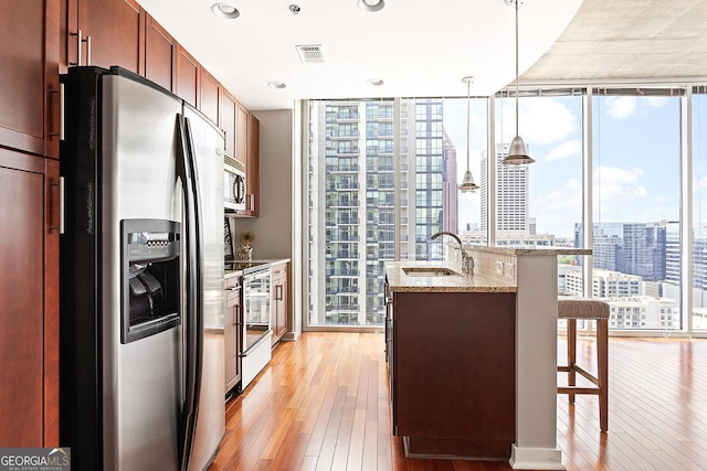 855 Peachtree St NE Unit 2203, Atlanta, GA 30308 - kitchen featuring stainless steel appliances, a sink, light wood-style floors, a wall of windows, and a city view