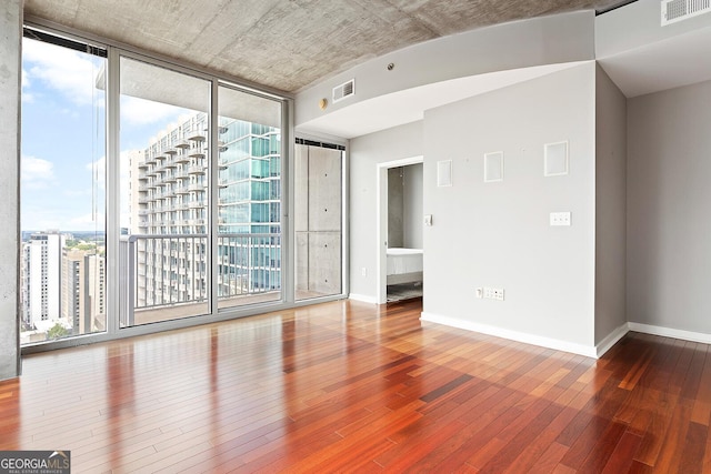 855 Peachtree St NE Unit 2203, Atlanta, GA 30308 - unfurnished room with hardwood / wood-style floors, baseboards, and expansive windows